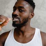 Close-up of a young man brushing his teeth, emphasizing oral hygiene and daily care routine.